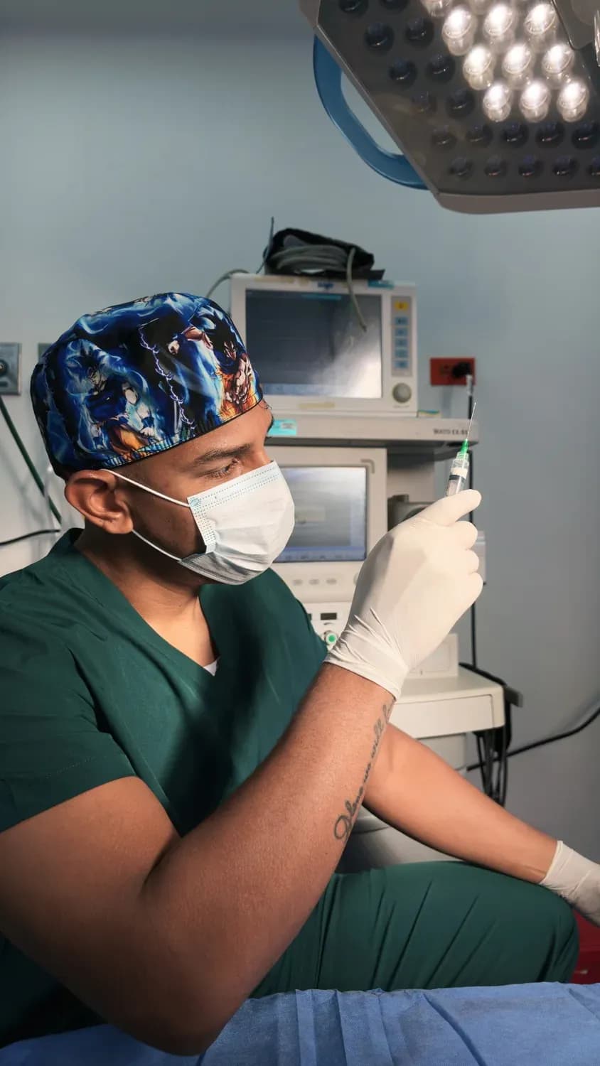 El Dr. Camelo carga la medicación bajo la lámpara del quirófano.