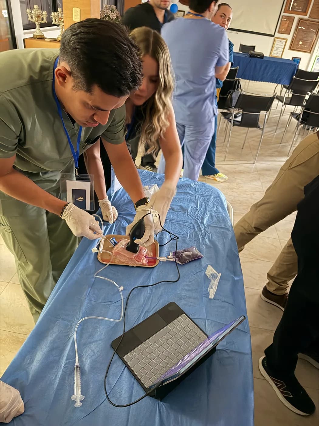 Dos participantes del taller practican una punción guiada por ecografía sobre modelo.