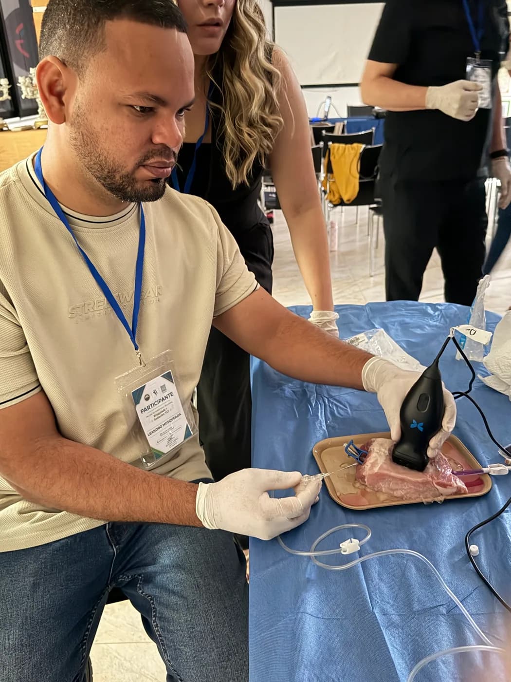 Un participante dirige la aguja con la sonda del ecógrafo durante el taller.
